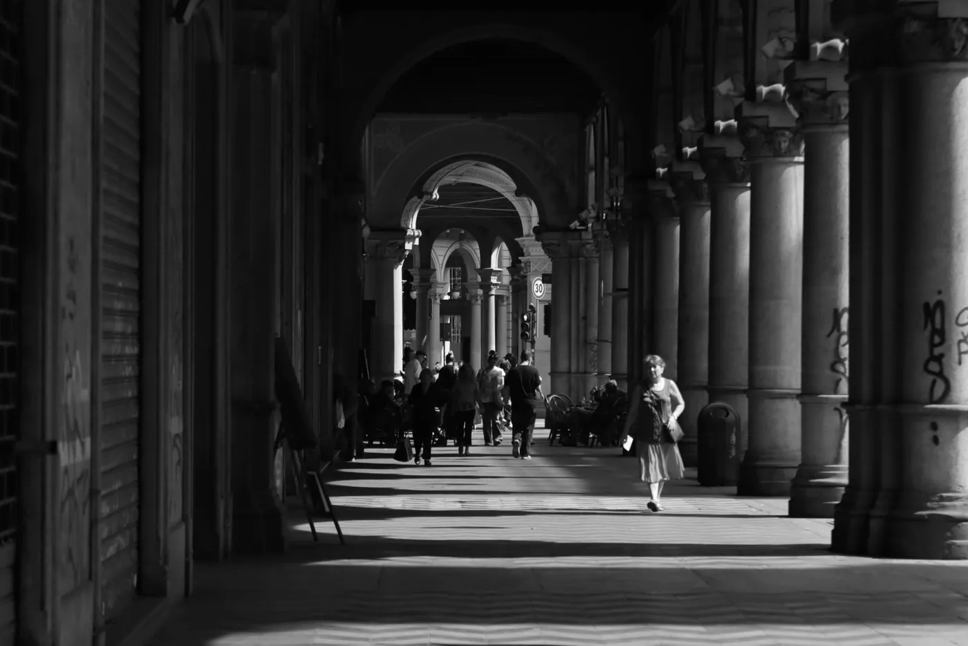 Long arcades in Turin with columns and passers-by