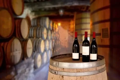 Wine bottles on a barrel in a wine cellar in Piedmont