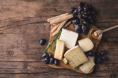 Platte mit Käse, Weintrauben und Honig