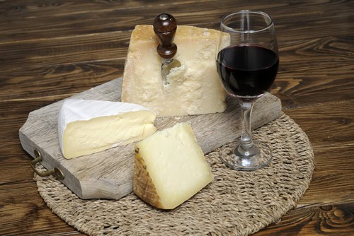 Wein und Käse auf einer Platte angerichtet